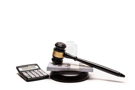 An isolated image of a judges gavel on a stack of cash with a calculator, signifying legal fines or bail