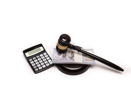 Una imagen aislada de un mazo de jueces en una pila de dinero en efectivo con una calculadora, lo que significa multas legales o fianza