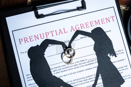 Photo for A prenuptial agreement with a silhouette of a couple and wedding rings, symbolizing marital contracts and legal preparation - Royalty Free Image