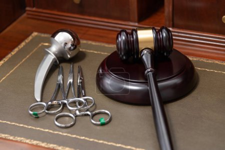 A professional judges gavel lies next to medical tools, symbolizing legal issues in healthcare