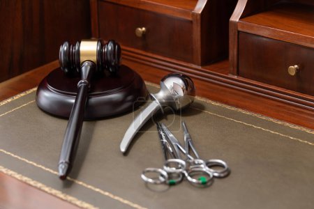 A professional judges gavel lies next to medical tools, symbolizing legal issues in healthcare