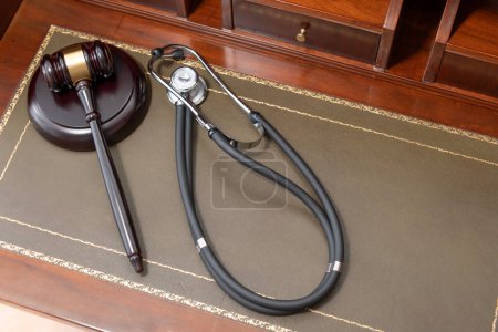 A close-up of a judges gavel and a black stethoscope on top of a legal book, signifying the intersection of law and medicine