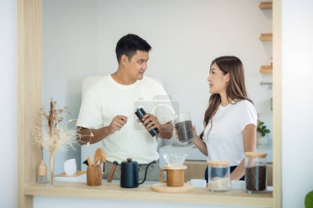 Photo for Couple or asian people to make, learn to ground coffee beans or brew coffee in kitchen home by grinder machine. Include cup, mug and kitchenware. Concept for lifestyle, love, happy, family, relationsh - Royalty Free Image