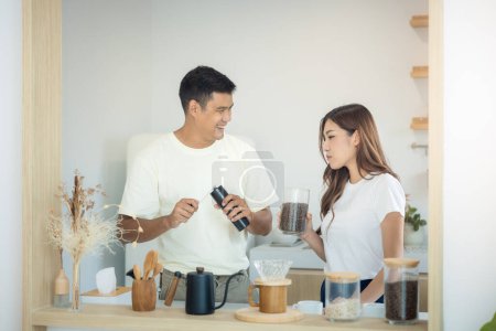 Photo for Couple or asian people to make, learn to ground coffee beans or brew coffee in kitchen home by grinder machine. Include cup, mug and kitchenware. Concept for lifestyle, love, happy, family, relationsh - Royalty Free Image