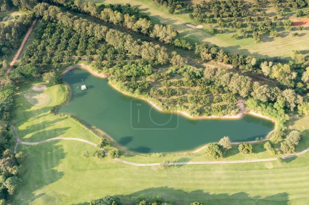 Photo for Landscape in golf course and water in lake or lakeside in aerial view. Include green field, lawn, grass. Design for golfers to play game, sport, outdoor recreation activity. - Royalty Free Image