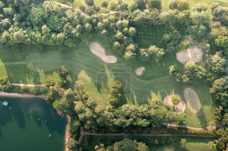 Foto de Paisaje en el campo de golf y el agua en el lago o junto al lago en vista aérea. Incluye campo verde, césped, hierba. Diseño para golfistas para jugar, deporte, actividad recreativa al aire libre. - Imagen libre de derechos