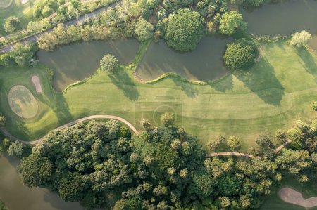 Téléchargez les photos : Landscape in golf course and water in lake or lakeside in aerial view. Include green field, lawn, grass. Design for golfers to play game, sport, outdoor recreation activity. - en image libre de droit