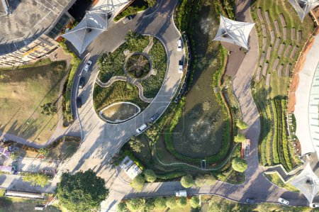 Téléchargez les photos : Garden, park in aerial view or top view. Green zone in city with beautiful landscape consist of plant, tree, water in lake or pond, roundabout or road for travel, parking, U-turn and decoration place. - en image libre de droit