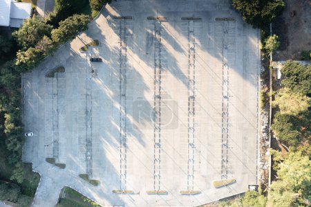 Foto de Car park in aerial view or top view. Empty space on concrete pavement floor at outdoor include many parking lot in row, line mark and lighting. Place outside airport, shopping mall for auto, vehicle. - Imagen libre de derechos