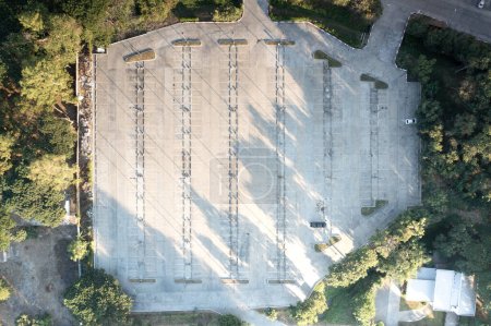 Photo for Car park in aerial view or top view. Empty space on concrete pavement floor at outdoor include many parking lot in row, line mark and lighting. Place outside airport, shopping mall for auto, vehicle. - Royalty Free Image