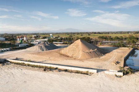 Photo for Pile of sand and rock or gravel in concrete plant with sky background in aerial view. Heap of aggregate or material from nature, mine or quarry for mix with cement, concrete for industry construction. - Royalty Free Image
