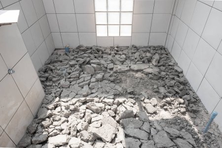 Scrap concrete in toilet room, construction site. Demolished work of tile and concrete floor. To breaking by jack hammer. Cause of bad skill worker. To remove, destruction and re-construction.