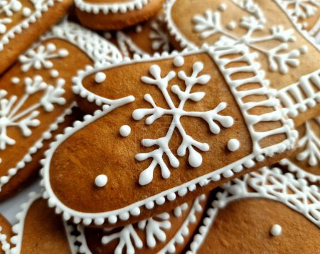 Téléchargez les photos : Biscuits au pain d'épice Gants de Noël décorés de glaçage royal, avec du sucre glace comme fond. Nourriture de Noël, fond pâtissier. Thème Nouvel An. Joyeux Noël et Joyeuses fêtes de fin d'année - en image libre de droit