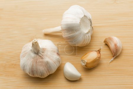 Photo for Garlic cloves and garlic bulb on wooden background, healthy food, copy space. Banner, cover, mockup, for design - Royalty Free Image