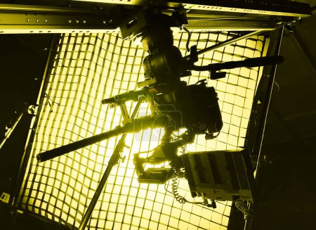 Filmkamera mit Makrolinse auf dem Schieberegler im Hintergrundlicht aus dem Rahmen mit Raster, die Sonnenstrahlen am Untergang. Supermakro