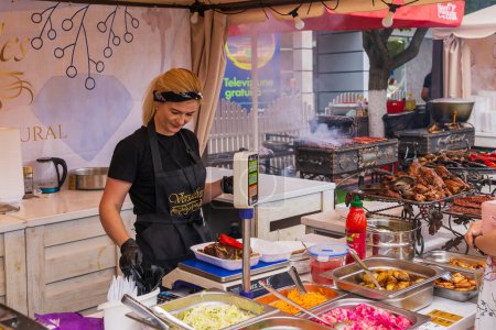 Photo for A vendor serves a customer at a street food festival. June 25, 2022 Balti Moldova. Illustrative editorial - Royalty Free Image