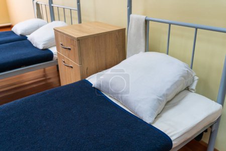 Photo for The made-up bed of a soldier in the barracks. Background with selective focus - Royalty Free Image