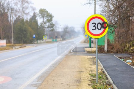Téléchargez les photos : Les vandales ont peint le chiffre zéro sur un panneau routier avec une limite de vitesse de 30 kilomètres à l'heure. 300 kilomètres par heure panneau arrière-plan - en image libre de droit