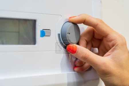 Foto de Dedos en el termostato de una caldera nueva. Fondo con enfoque selectivo y espacio de copia para texto - Imagen libre de derechos