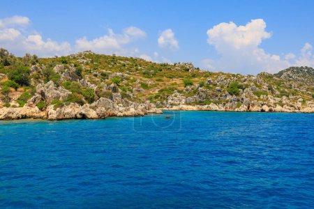 View of the rocky shore from the sea. Background with selective focus and copy space for text. Mediterranean Sea in Turkey. Popular tourist places