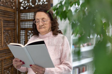 Téléchargez les photos : Femme âgée caucasienne lisant un livre. Loisirs et divertissements pour les retraités. - en image libre de droit