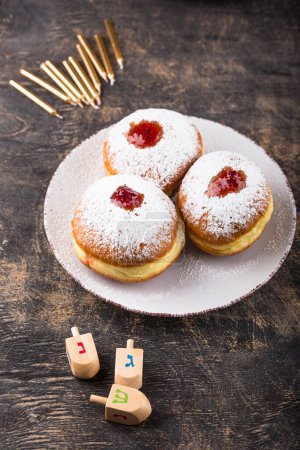 Photo for Traditional Jewish holiday Hanukkah food. Doughnuts sufganiot, candles and dreidl - Royalty Free Image