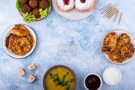 Photo for Traditional Jewish holiday Hanukkah food. Doughnuts sufganiot, potatoes pancakes latkes, falafel, candle and dreidl - Royalty Free Image