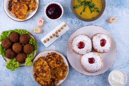 Photo for Traditional Jewish holiday Hanukkah food. Doughnuts sufganiot, potatoes pancakes latkes, falafel, candle and dreidl - Royalty Free Image
