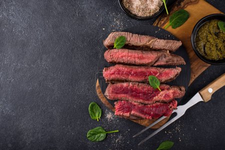 Photo for Different degrees of steak roasting. Steak with blood, medium to high roast steak on a wooden board - Royalty Free Image