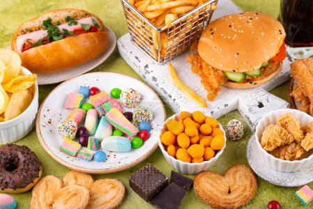 Téléchargez les photos : Assortiment de malsaine malbouffe. Burger, frites, hot dog, snack et bonbons - en image libre de droit