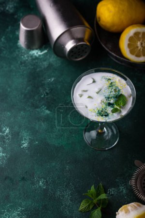 Photo for Cocktail or mocktail with lemon and mint on green background - Royalty Free Image