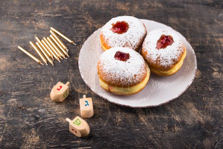 Photo for Traditional Jewish holiday Hanukkah food. Doughnuts sufganiot, candles and dreidl - Royalty Free Image