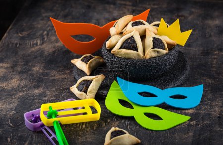 Téléchargez les photos : Jewish holiday Purim with carnival mask, traditional cookies Hamantaschen and rattle - en image libre de droit