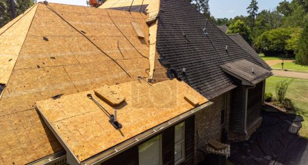 House with new roof being installed after hail damage