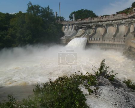 Photo for Water cascading over an old dam in nature. - Royalty Free Image