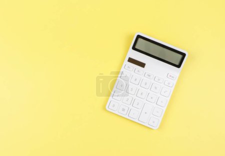 Photo for Top view or flat lay of white  calculator on yellow  background with copy space. - Royalty Free Image
