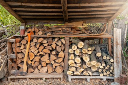 Téléchargez les photos : Hangar à bois organisé prêt à utiliser le bois dans la cheminée à l'intérieur de la maison en hiver. Photo de haute qualité - en image libre de droit