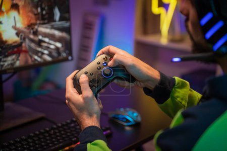 Photo for Gamer hands playing with joystick on green screen in trendy and stylish room with neon light. Streaming video games concept. High quality POV photo - Royalty Free Image