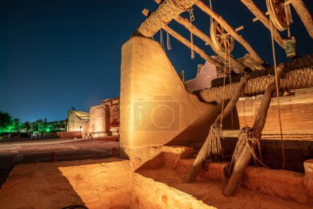 Foto de Diriyah casco antiguo bien con pared resaltada en el fondo por la noche, Riad, Arabia Saudita - Imagen libre de derechos