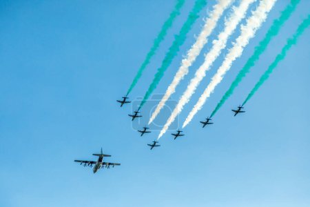 Bomber leading fighter jets squadron with traces in Saudi Arabian national flag colors, at Jeddah air show