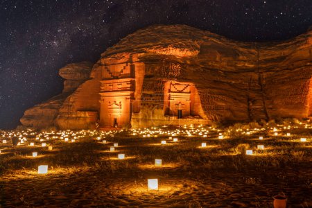 Foto de Cielo estrellado sobre las antiguas tumbas nabateas de la ciudad de Mada 'in Salih Hegra iluminada, panorama nocturno, Al Ula, Arabia Saudita - Imagen libre de derechos