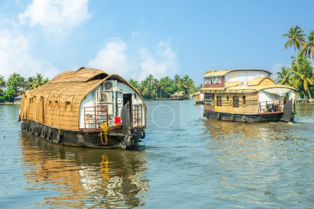 Foto de Casas flotantes tradicionales de la India flotando en el río Pamba, con palmeras en la costa, Alappuzha, Kerala, India del Sur - Imagen libre de derechos