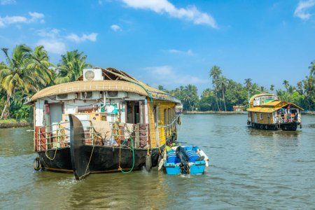 Foto de Casas flotantes tradicionales de la India flotando en el río Pamba, con palmeras en la costa, Alappuzha, Kerala, India del Sur - Imagen libre de derechos