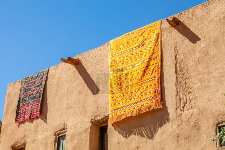 Téléchargez les photos : Tapis arabes ornés suspendus au toit de maisons traditionnelles en boue, Al Ula, province de Médine, Arabie Saoudite - en image libre de droit