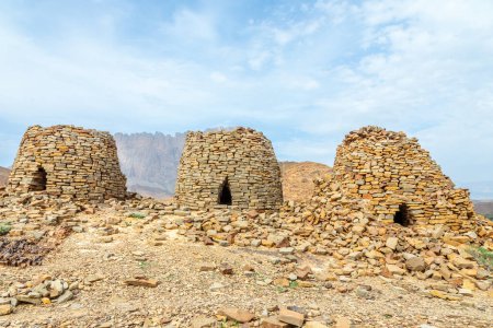 Tombes anciennes de ruches en pierre avec la montagne Jebel Misht en arrière-plan, site archéologique près d'al-Ayn, sultanat d'Oman
