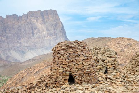Tombes anciennes de ruches en pierre avec la montagne Jebel Misht en arrière-plan, site archéologique près d'al-Ayn, sultanat d'Oman