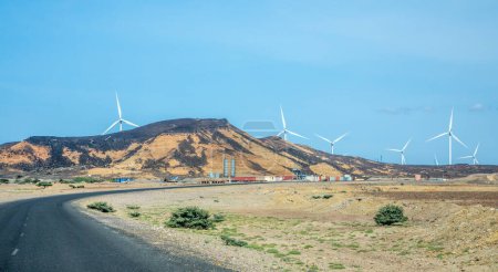 Straße mit Windkraftanlagen Generatoren von Netzwerkfarmen, die hinter dem Hügel stehen, Ghoubet, Arta Region, Dschibuti
