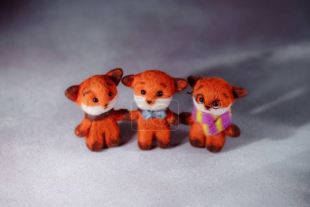 Handicraft hobby concept felting children's toys. Soft toy red fox with a warm scarf. Hobbies to improve psychological well-being.