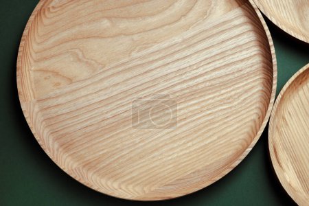Photo for Wooden flat plates on a green background. The concept of ecological tableware. Products for modern kitchen. Zero emissions. - Royalty Free Image