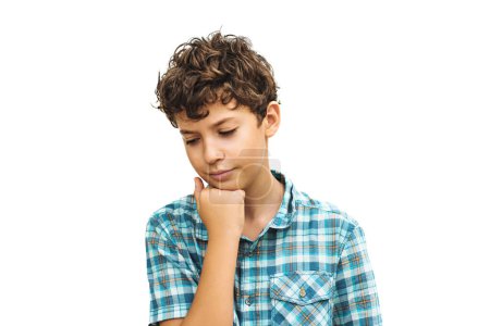 Téléchargez les photos : A 10-year-old caucasian boy with light brown hair, wearing a checkered shirt, looking sulky as he rests his head on his fist. This image represents childhood emotions and expressions - en image libre de droit